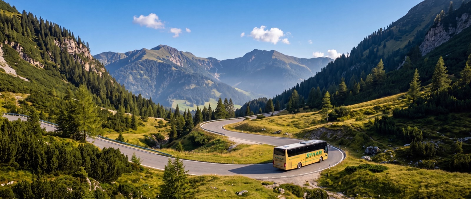Reisebus von Staab auf einer sonnigen Serpentinenstraße in den Alpen