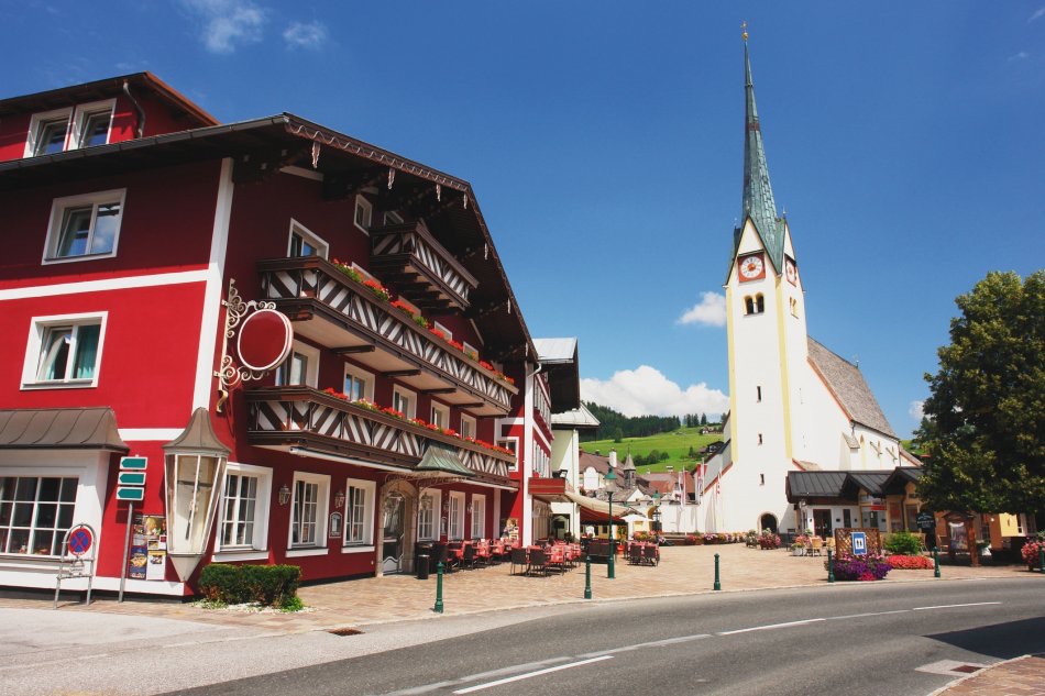 Roter Gasthof und Pfarrkirche im Ortszentrum von Abtenau